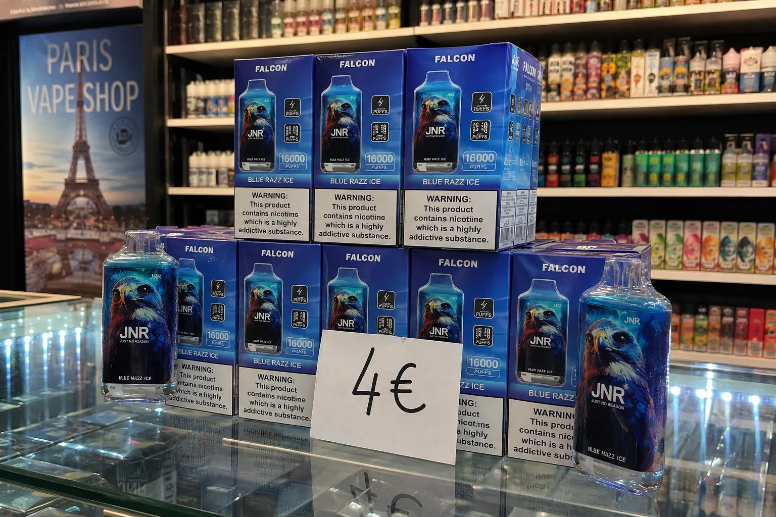 Boxes of Falcon Blue Razz Ice vapes showcasing 16,000 puffs, displayed on a counter with pricing and Paris Vape Shop signage in the background.
