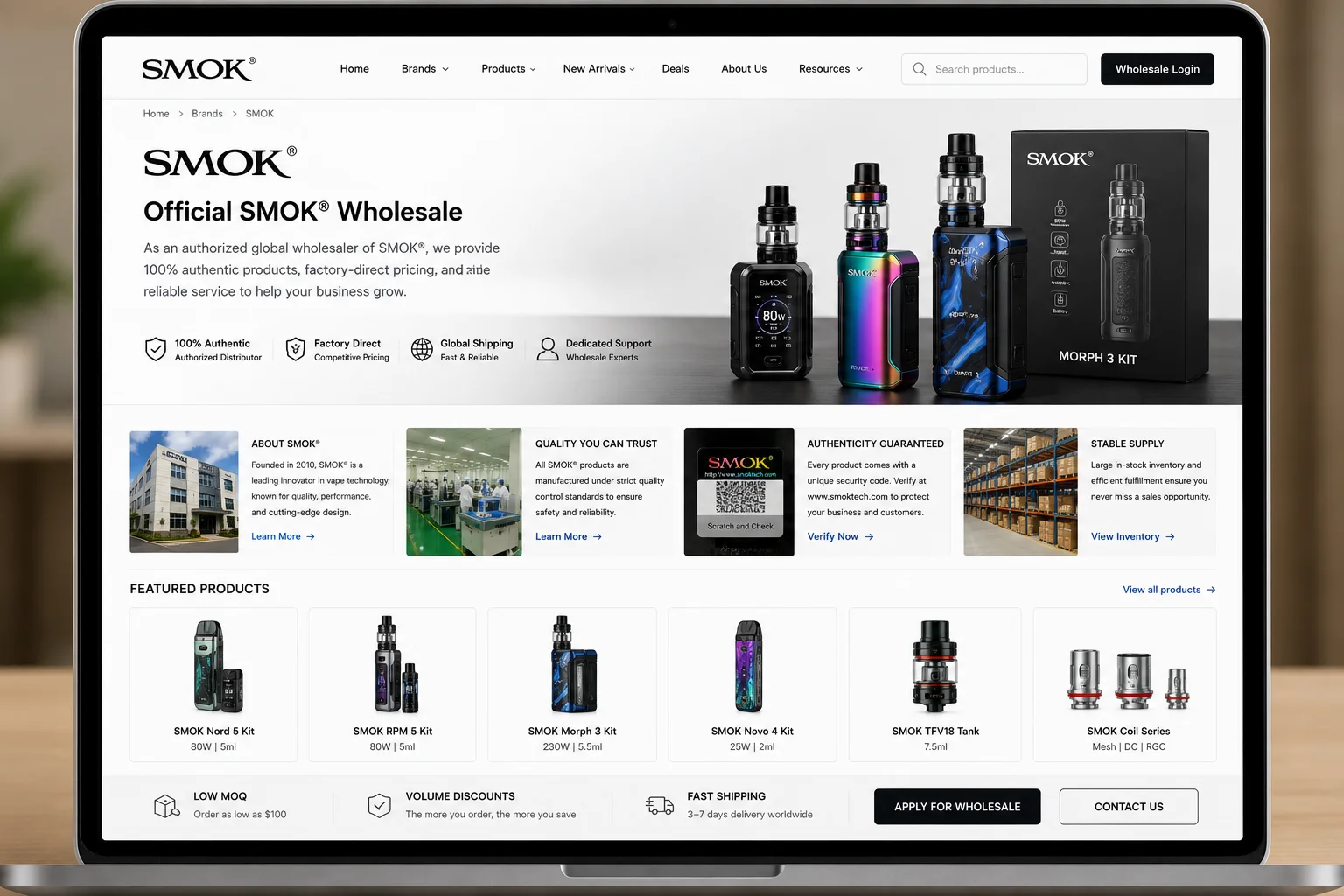 Laptop screen displaying the official SMOK wholesale website, featuring vape kits, tanks, and coils with product details and global shipping options.