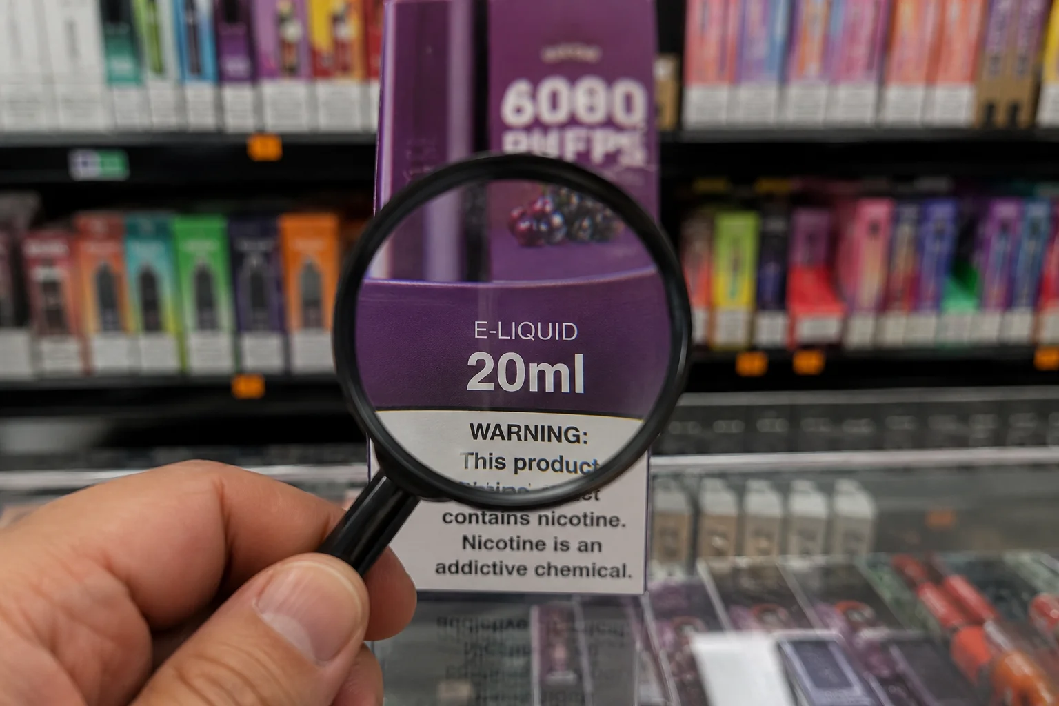 An image magnifying the 'ml' spec on a vape package, with the puff count blurred in the background